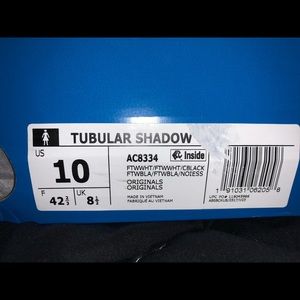 White Adidas Tubular Shadow Sneakers.